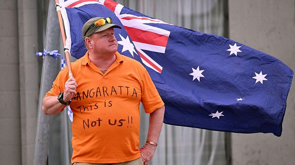 Woman waving Australian flag outside office