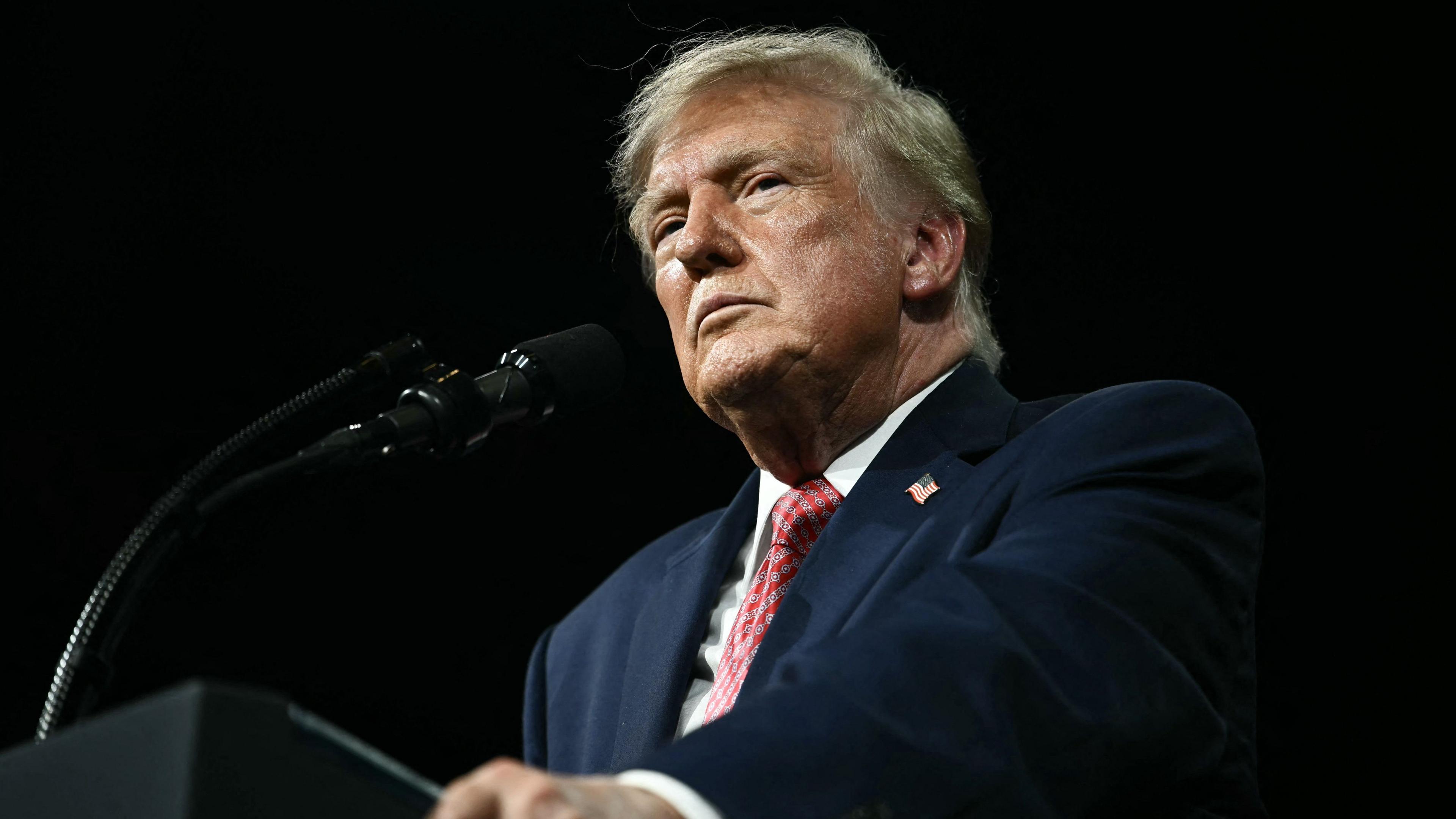 Former President Trump stands at a podium