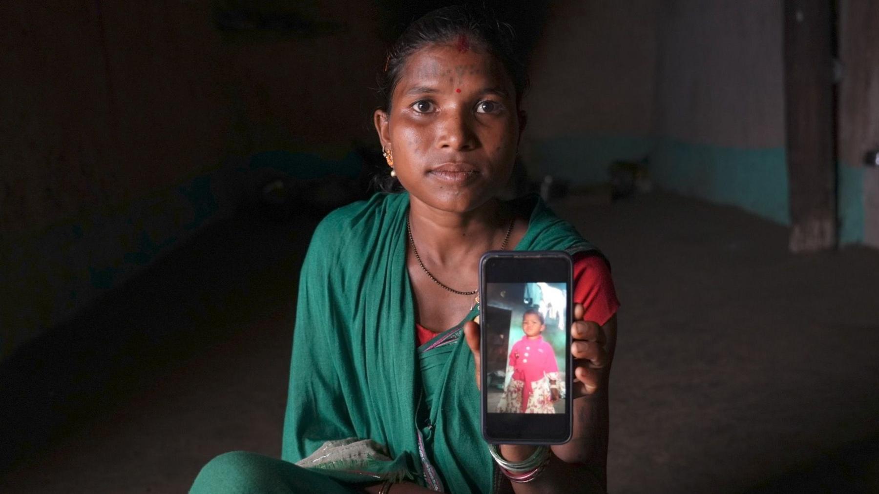 Koushila Markam holds a photograph of her daughter, Bamita, who died aged three