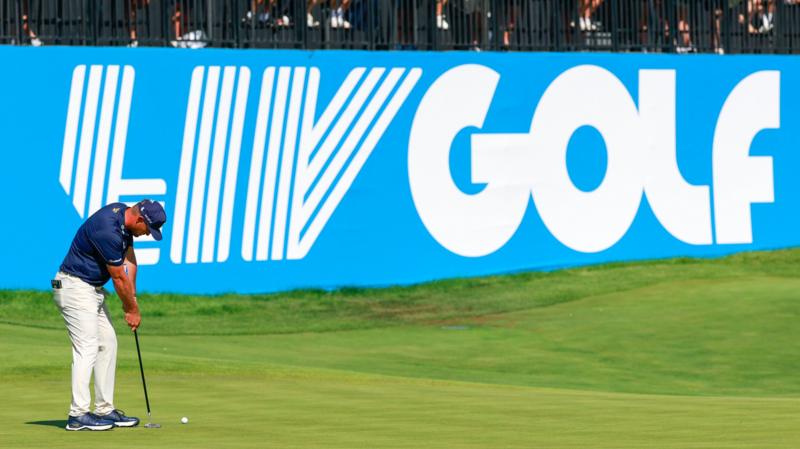 Golfer Bryson DeChambeau in front of a LIV Golf sign