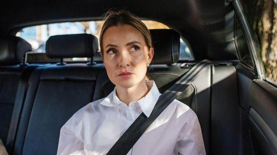 Passenger in a quiet electric car looking uncomfortable