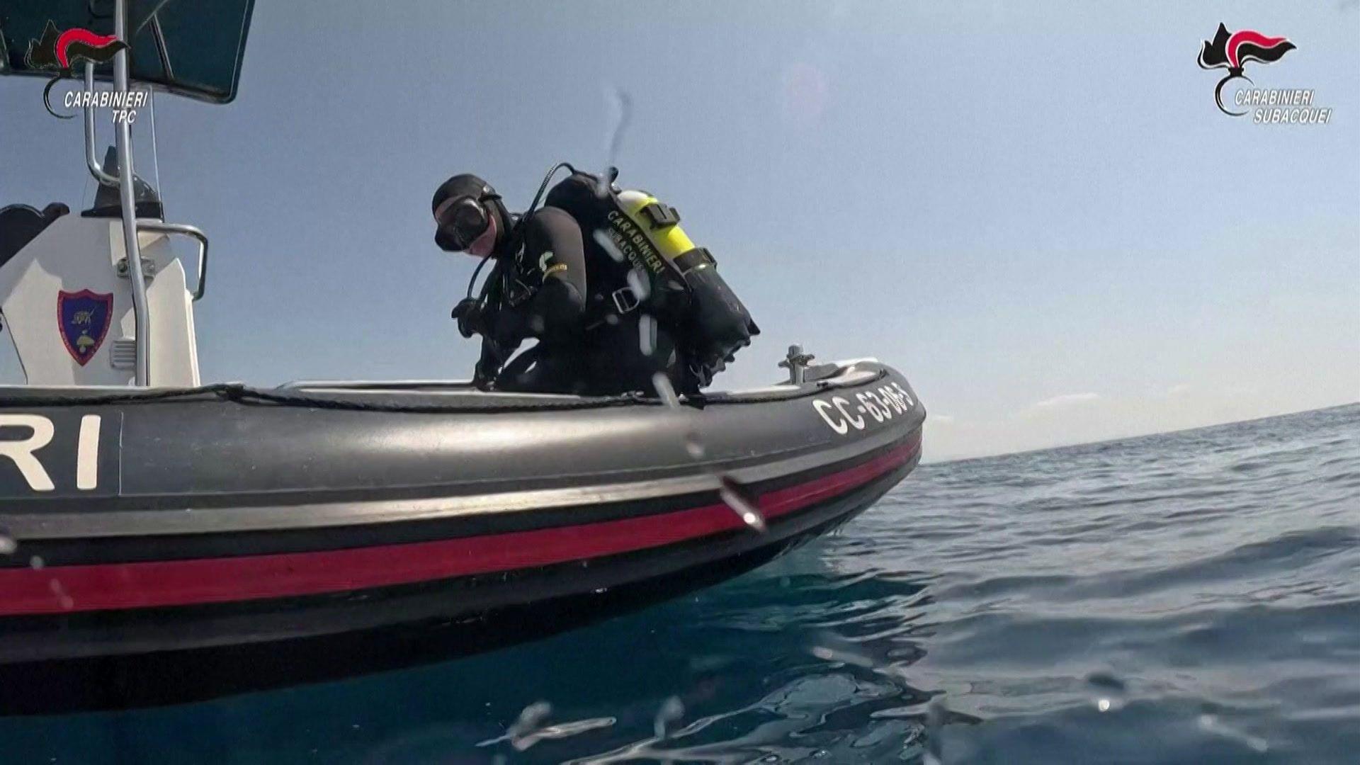 Diver standing on a small boat near the wreck site