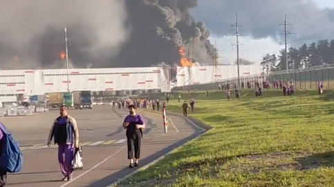 Workers evacuate a burning Wildberries warehouse